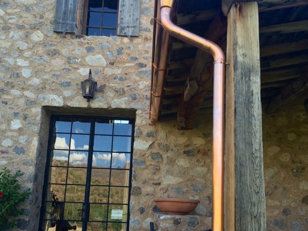 City Seamless half-round rain gutter with downspout routing on a custom home.