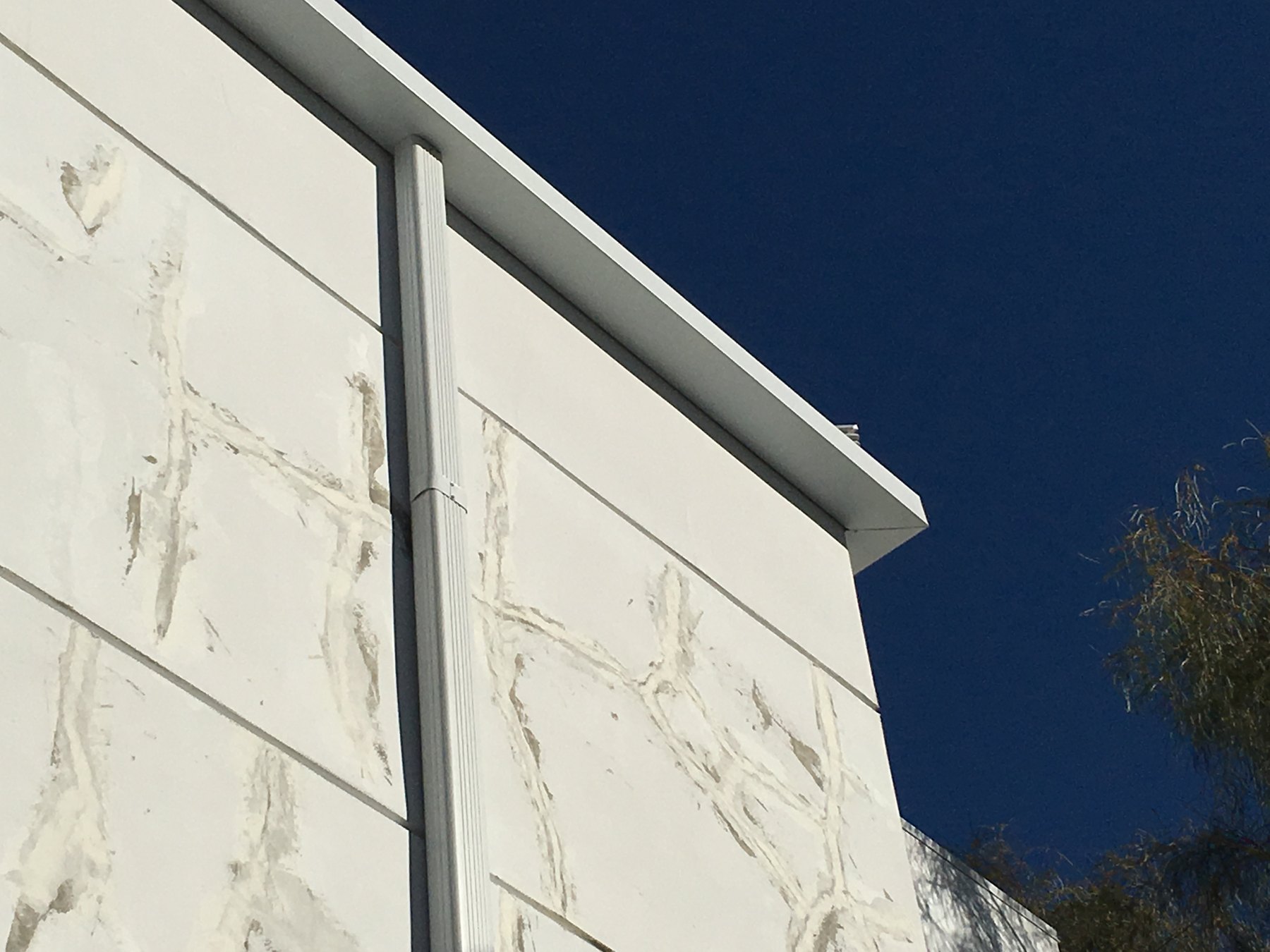 White seamless gutter installed on exterior wall